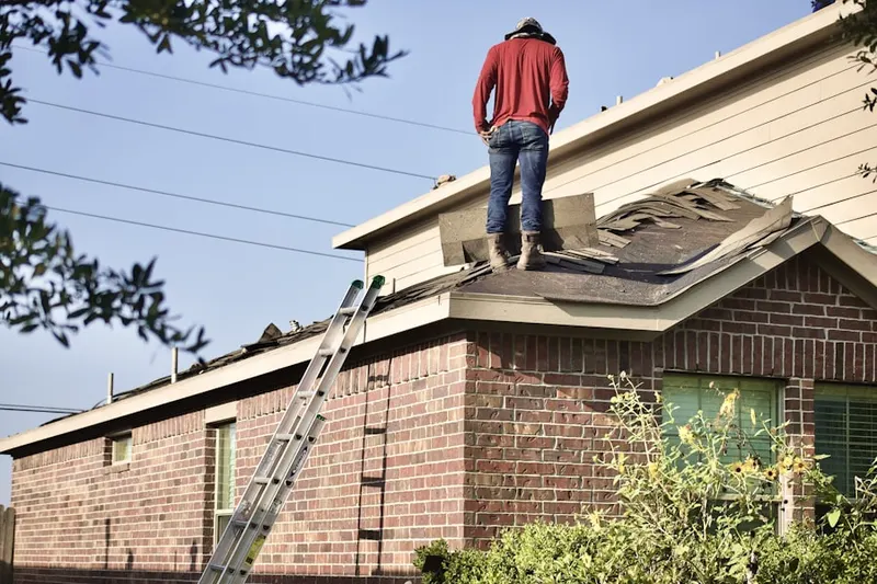 Professional roofer working on a residential roof in The Village at Little Falls
